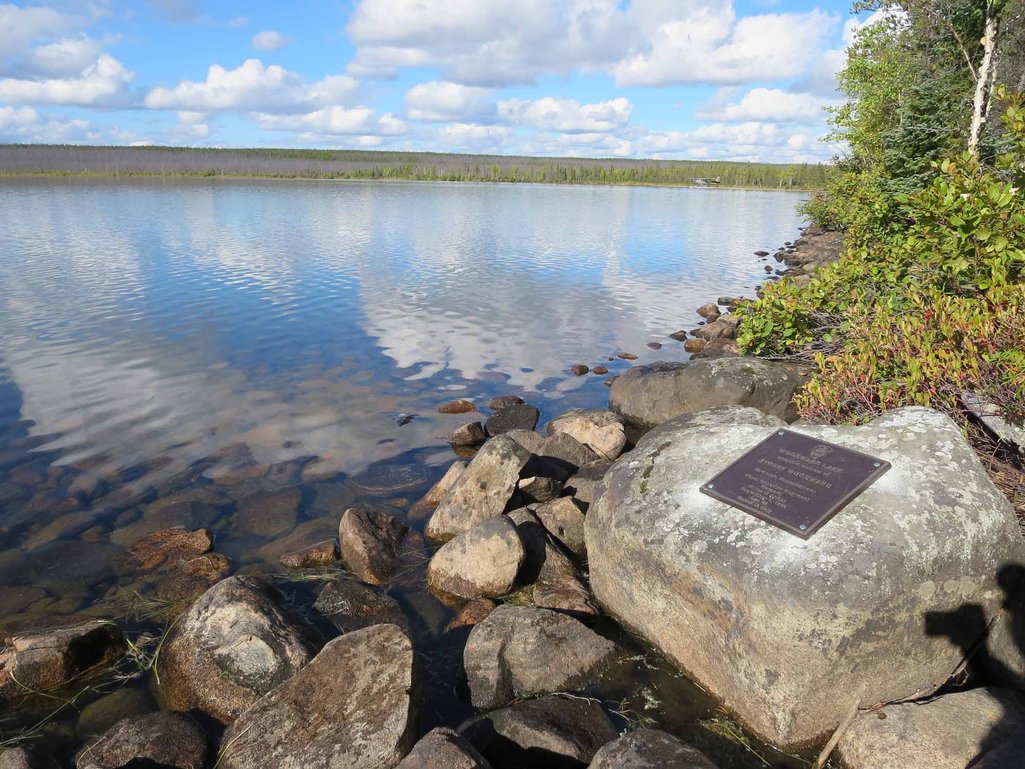 Photo of a geomemorial plaque installed on a large rock in northern saskatchewan on the shores of a lake