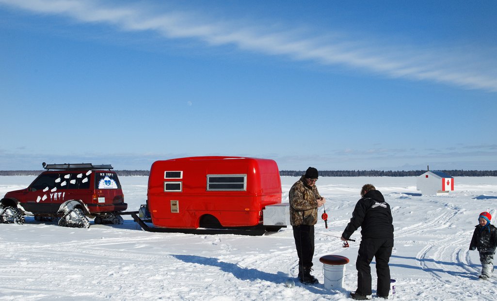 picture of people ice fishing outside on a sunny winter day 