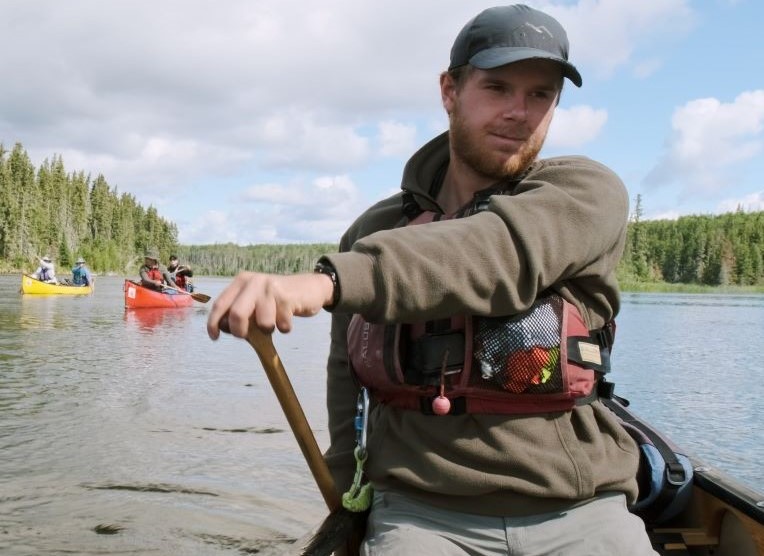 a man sitting in a canoe on a lake
