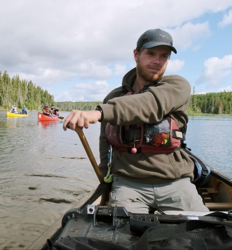 a man sitting in a canoe on a lake